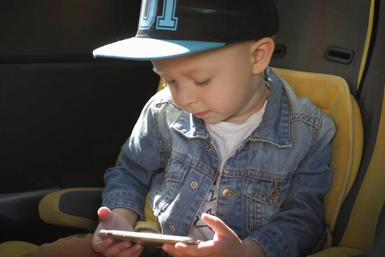 mały chłopiec patrzy w ekran smartfona mały chłopiec patrzy w ekran smartfona