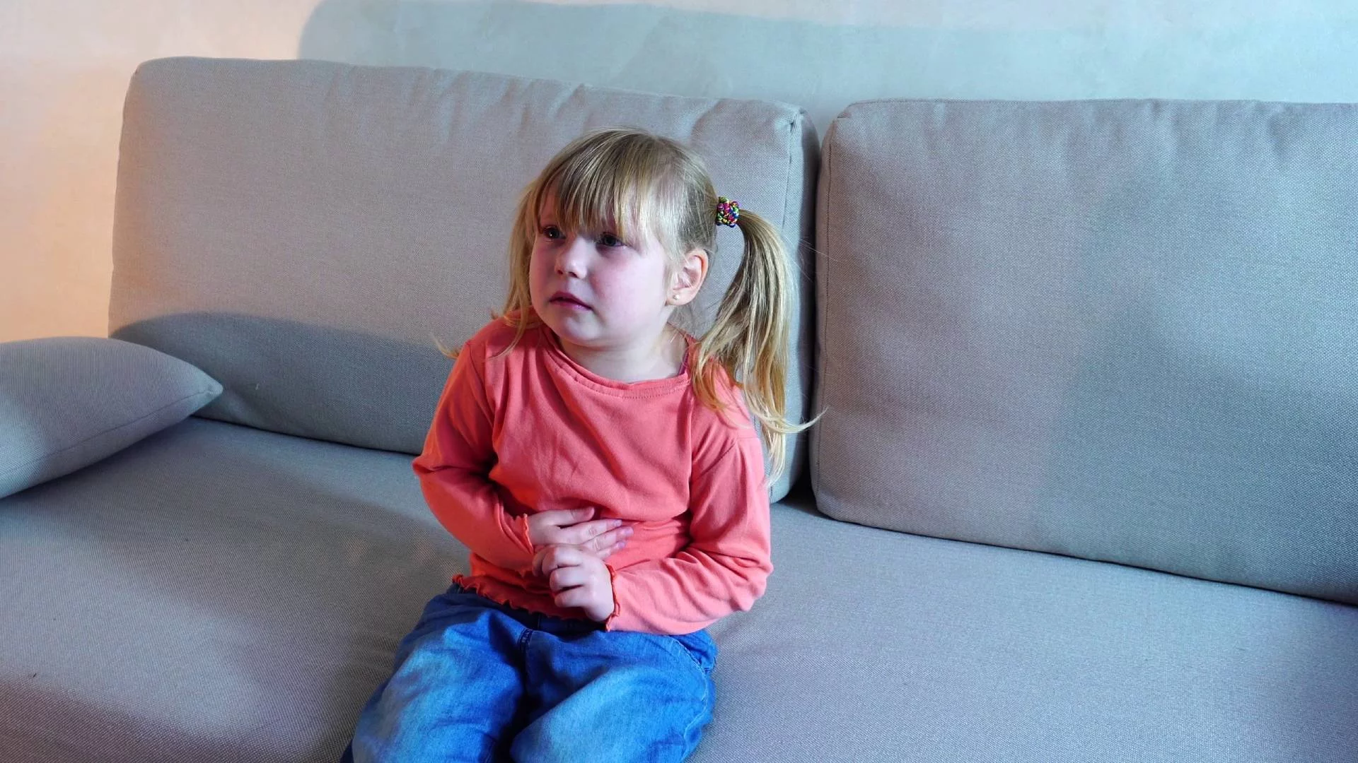 mała zapłakana dziewczynka siedzi na kanapie
