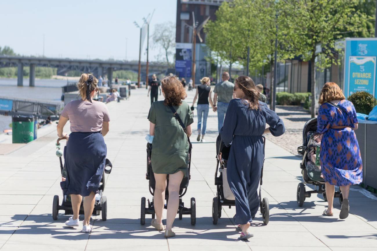 Matki pobierające 800 plus z dziećmi w wózkach na spacerze.