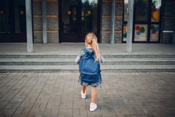 Dziewczynka idzie z plecakiem do szkoły.