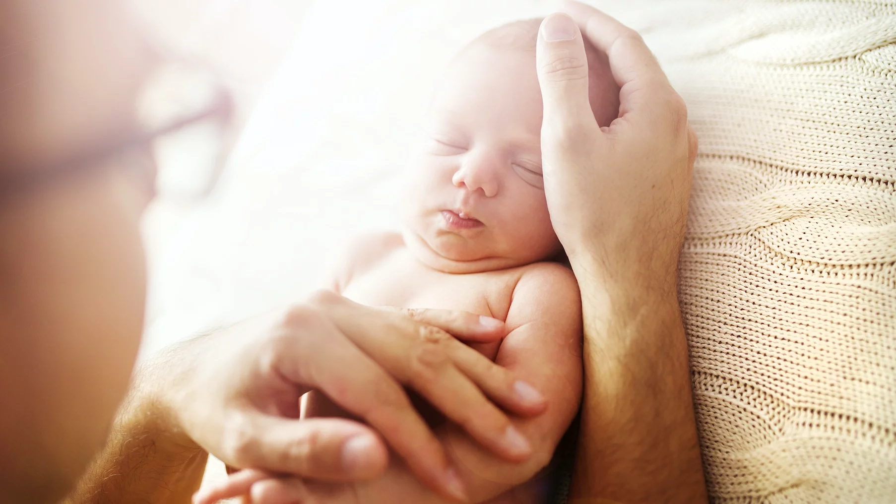 Na zdjęciu tata tuli noworodka