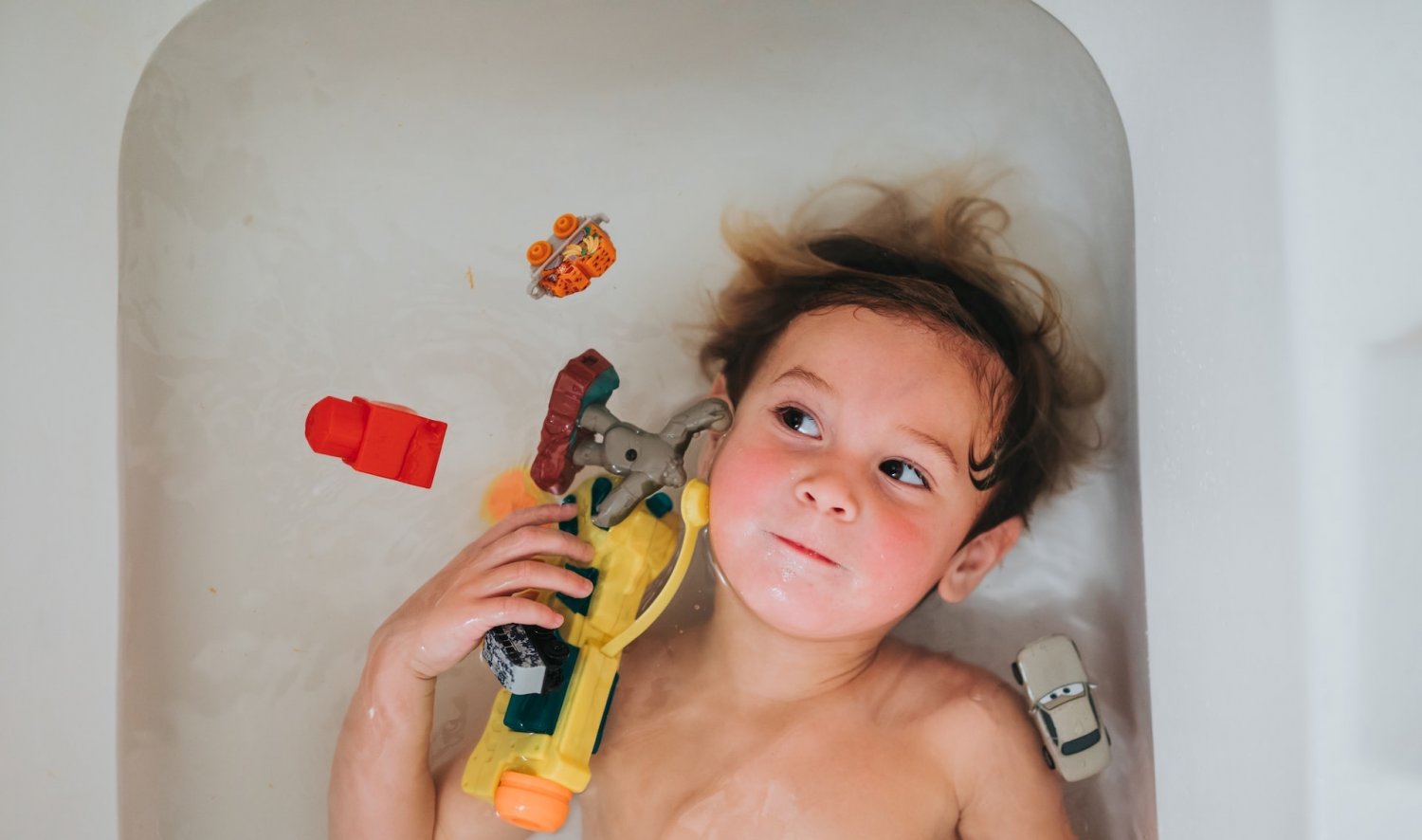 Chłopczyk w wannie z zabawkami.