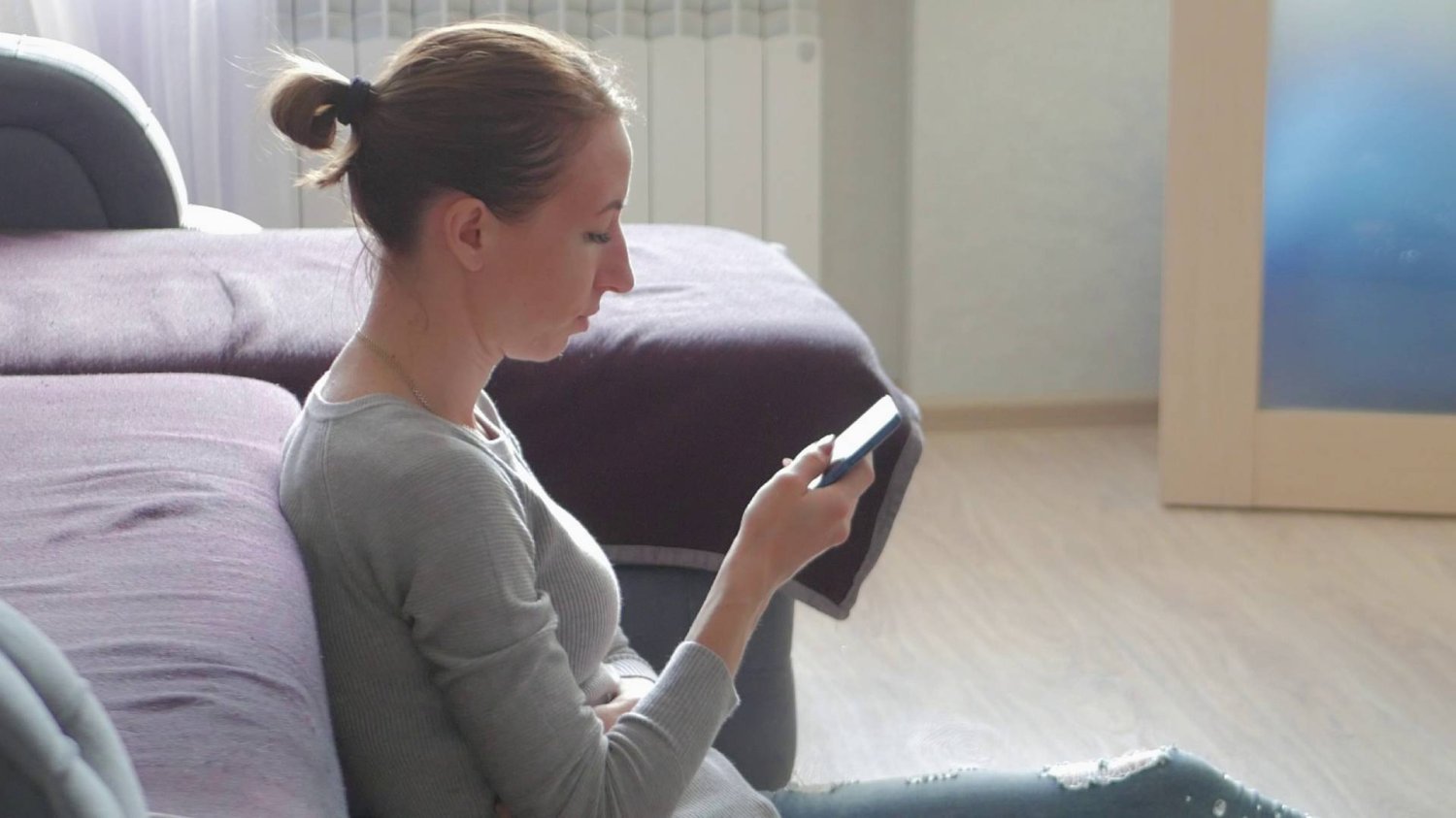 mama czytająca na smartfonie wiadomości na grupie dla rodziców