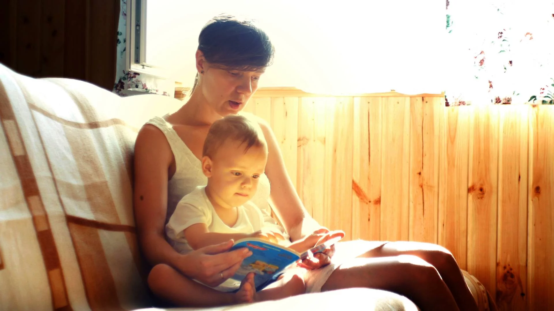 niania czyta książkę małemu dziecku