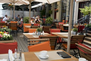 Restauracyjny ogródek, w którym rodzice z niemowlakiem jedli obiad.
