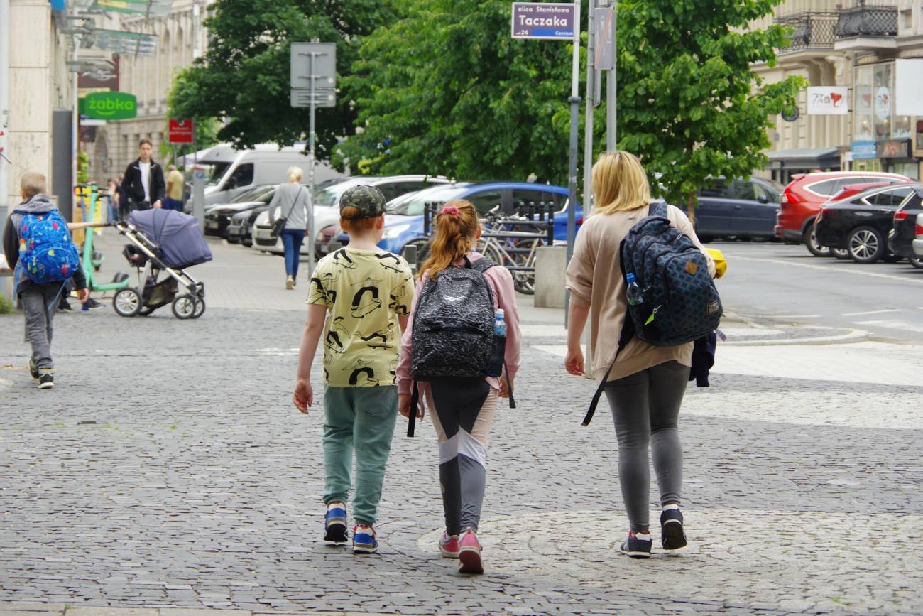 Kobieta idzie przez miasto z dziećmi. Kobieta idzie przez miasto z dziećmi.