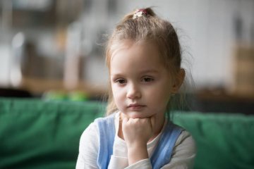 Mała dziewczynka ogląda telewizję.