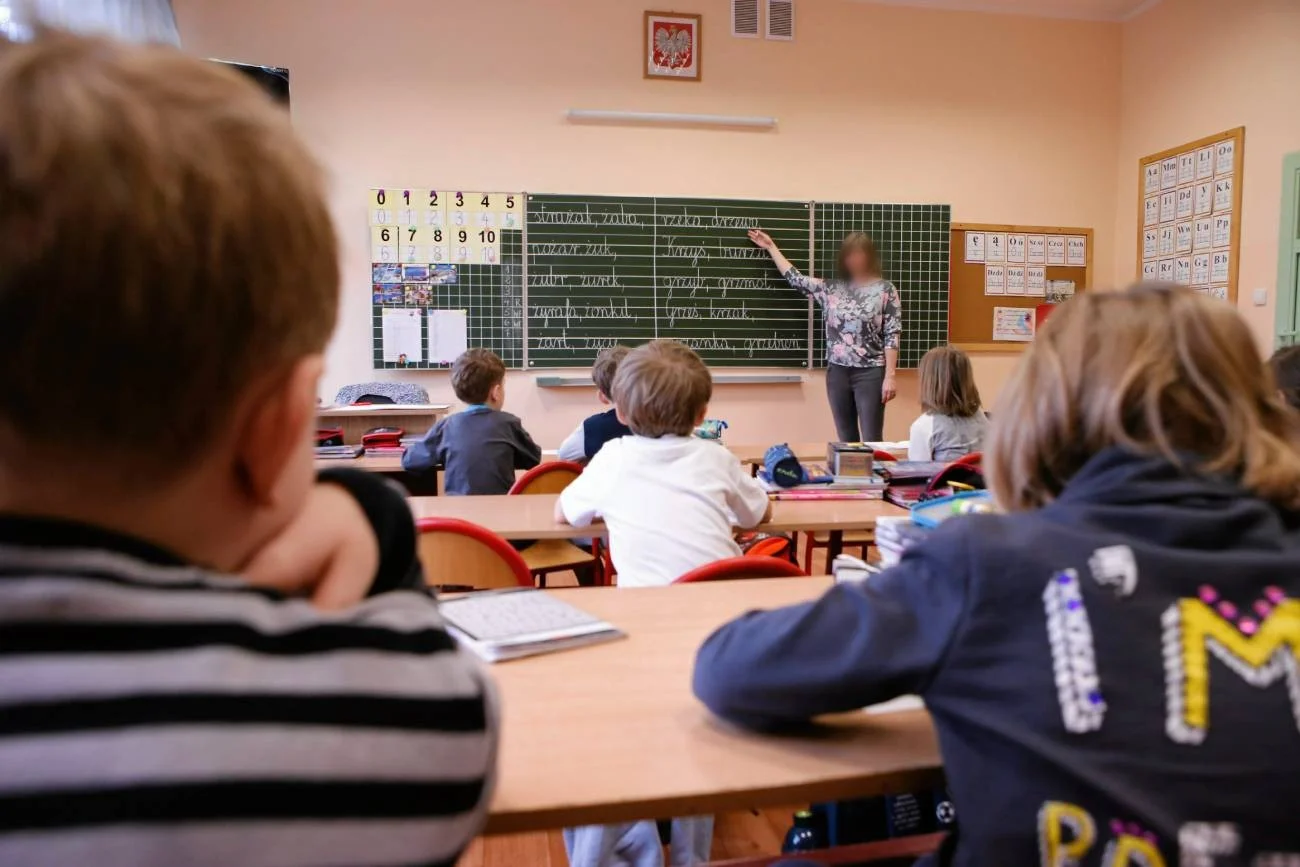 nauczycielka prowadzi w szkole podstawowej lekcję nauczycielka prowadzi w szkole podstawowej lekcję