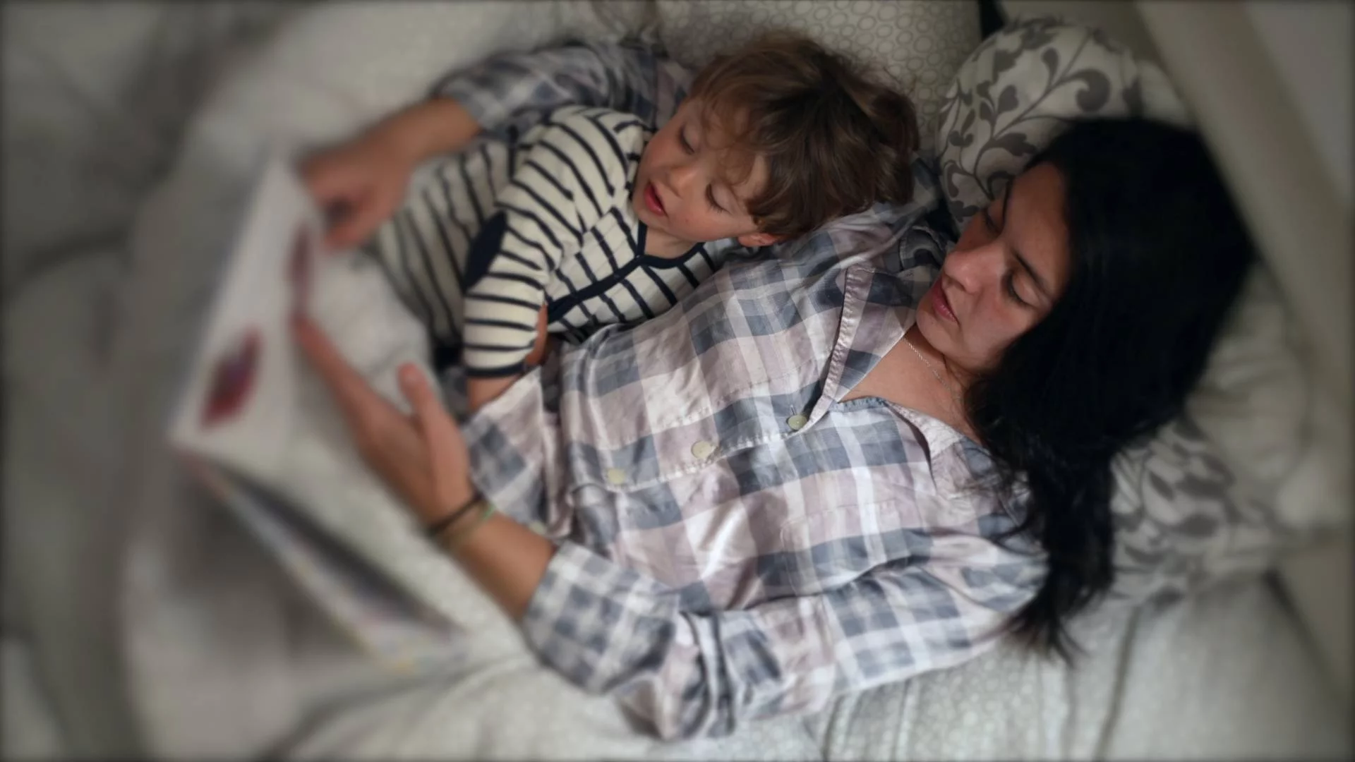 mama z dzieckiem czyta w łóżku książkę