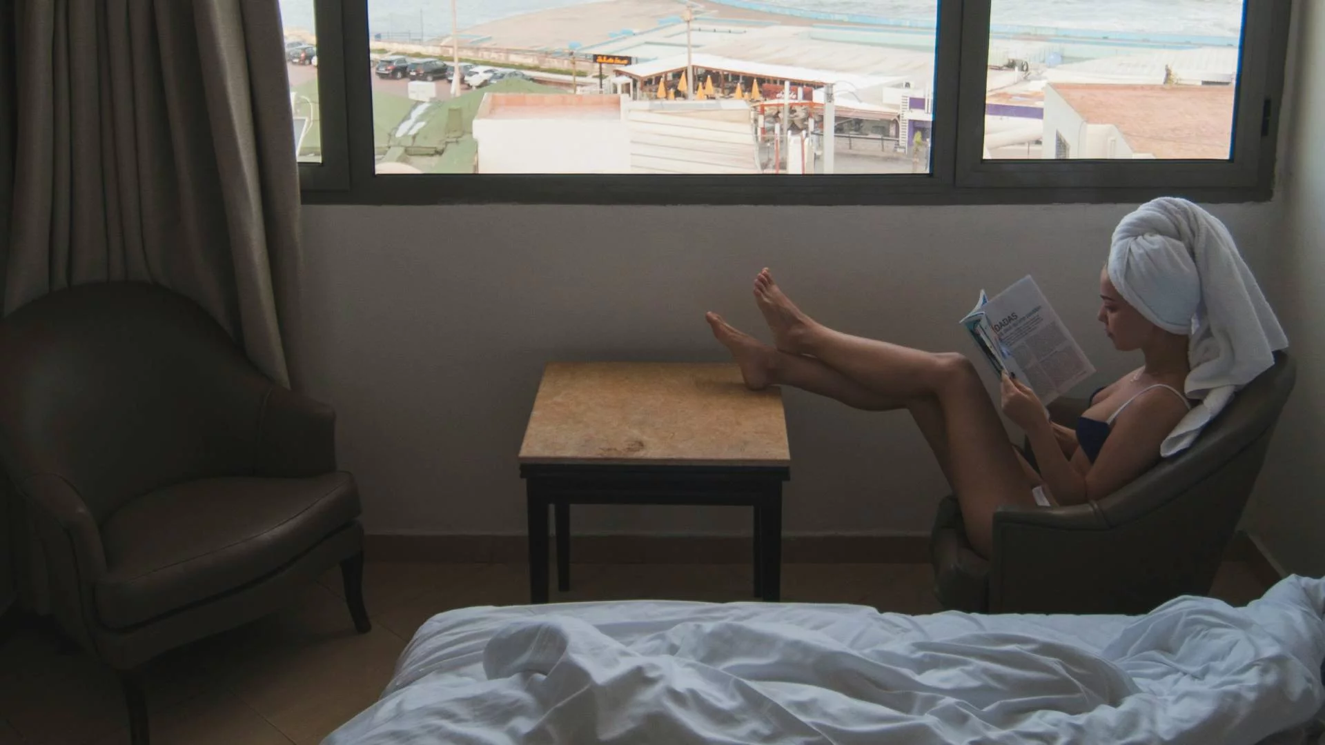 kobieta odpoczywa w hotelu nad morzem, czyta książkę w pokoju