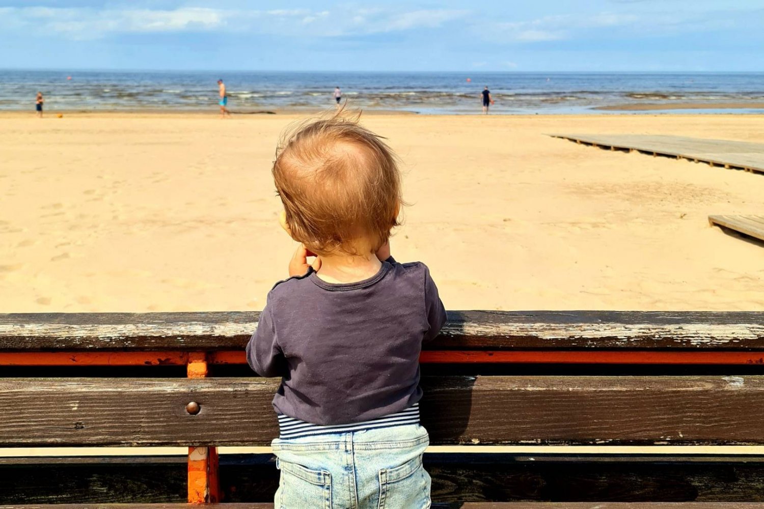 małe dziecko patrzy na morze i plażę