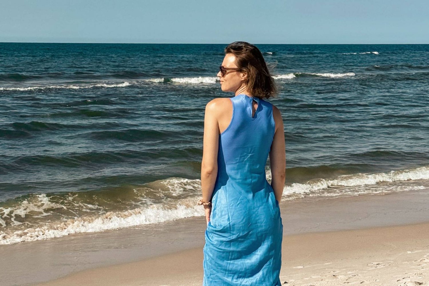 mama odpoczywa na plaży, patrząc w morze