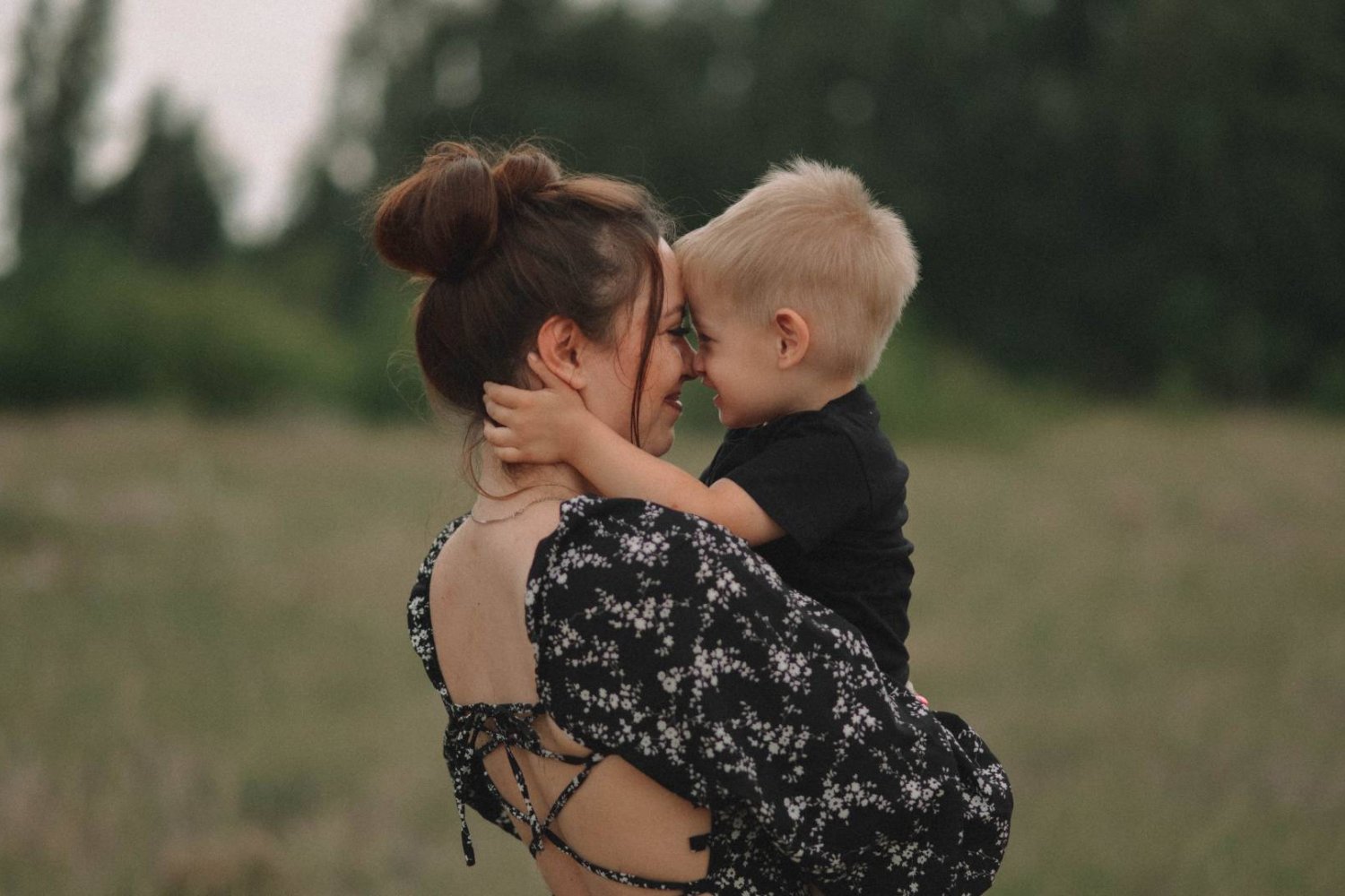 mama przytula synka na łące
