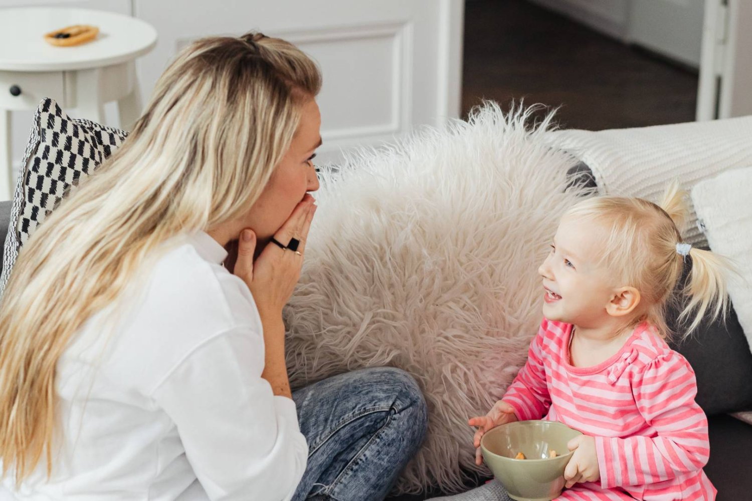 mama rozmawia i bawi się z córką na kanapie