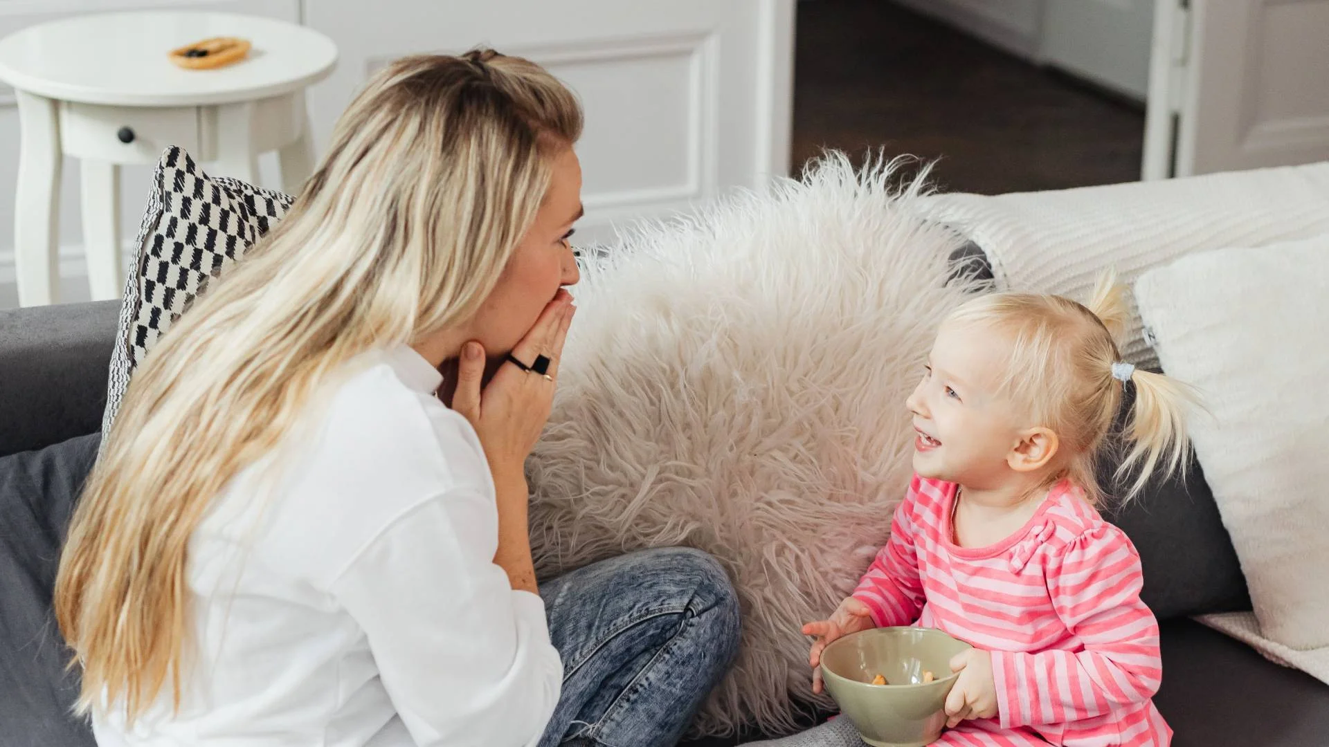 mama rozmawia i bawi się z córką na kanapie