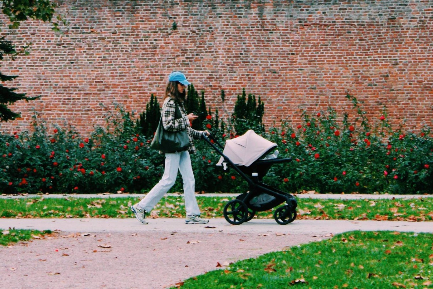 młoda mama z dzieckiem w wózku na spacerze