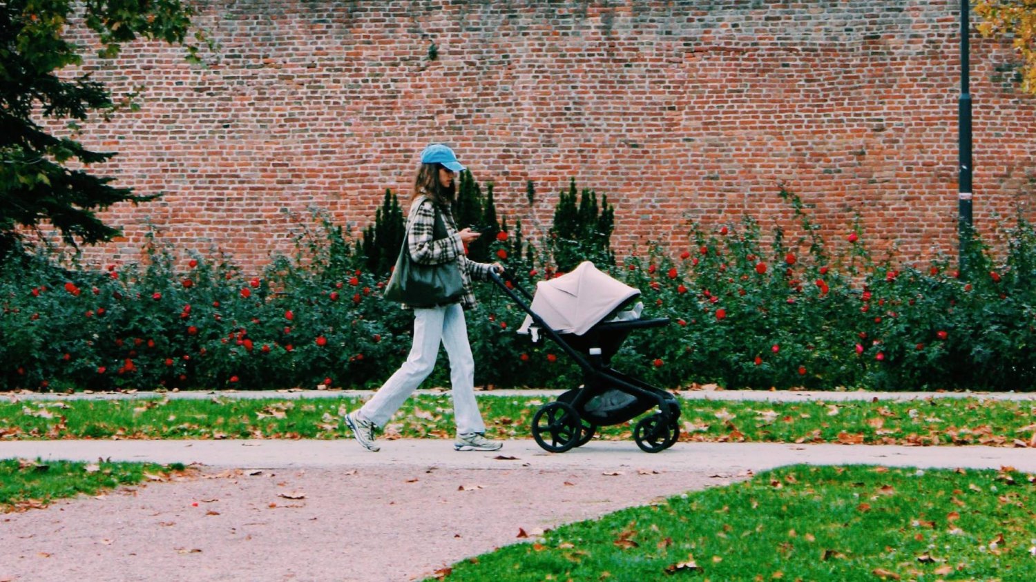 młoda mama z dzieckiem w wózku na spacerze