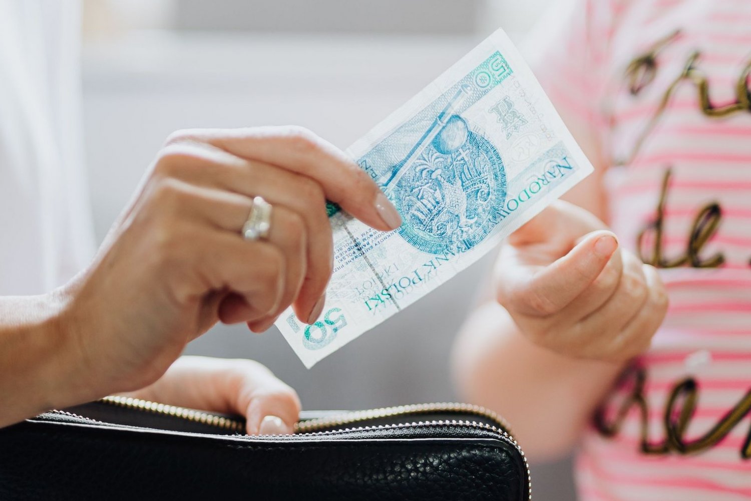 Na zdjęciu mama daje dziecku 50 zł