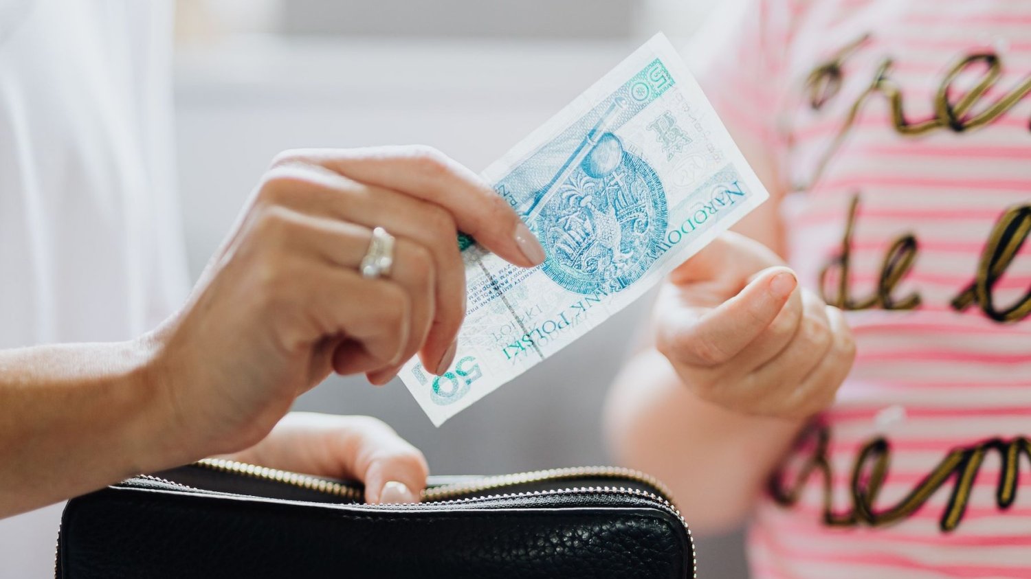 Na zdjęciu mama daje dziecku 50 zł
