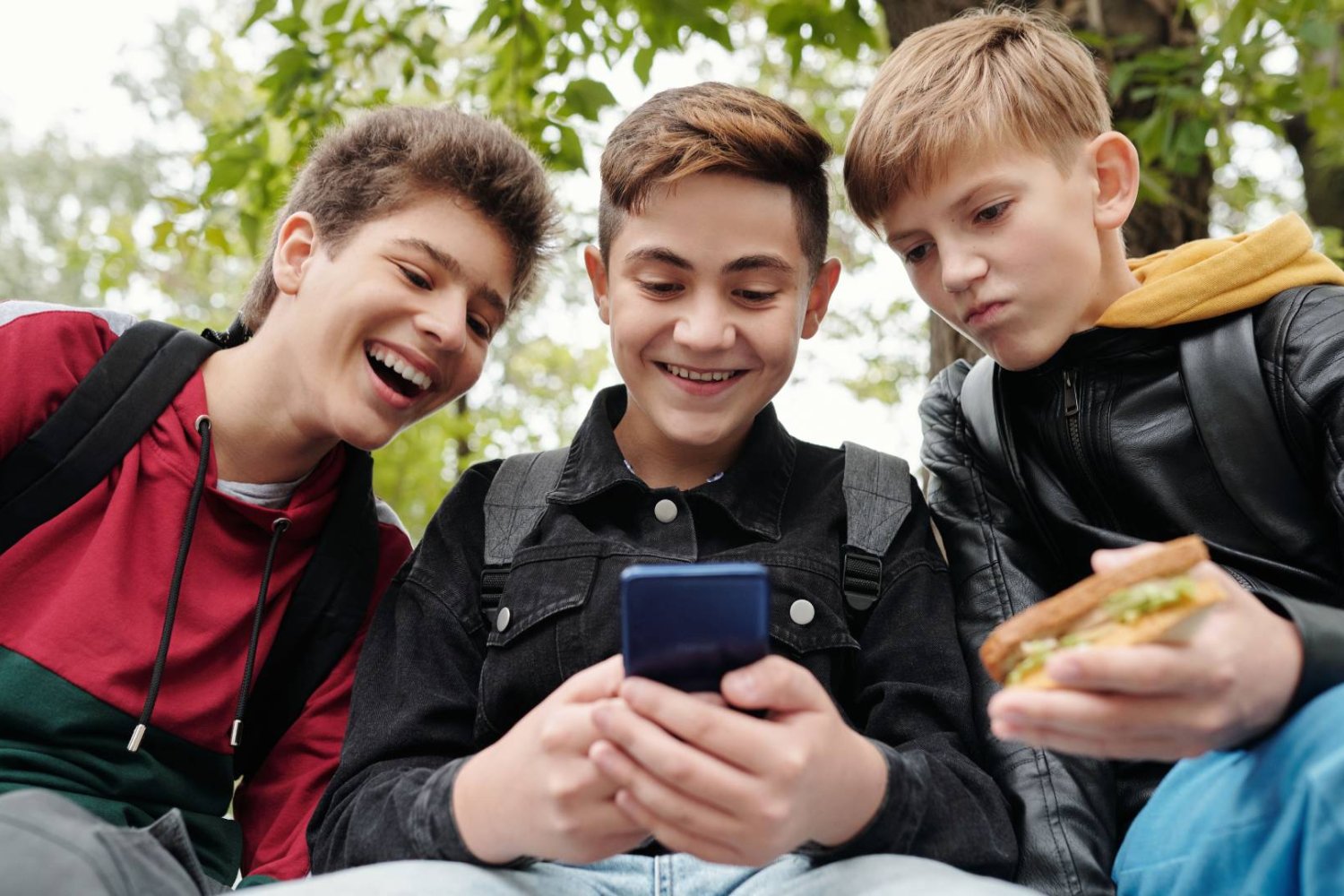 nastolatki patrzą roześmiani w ekran smartfona