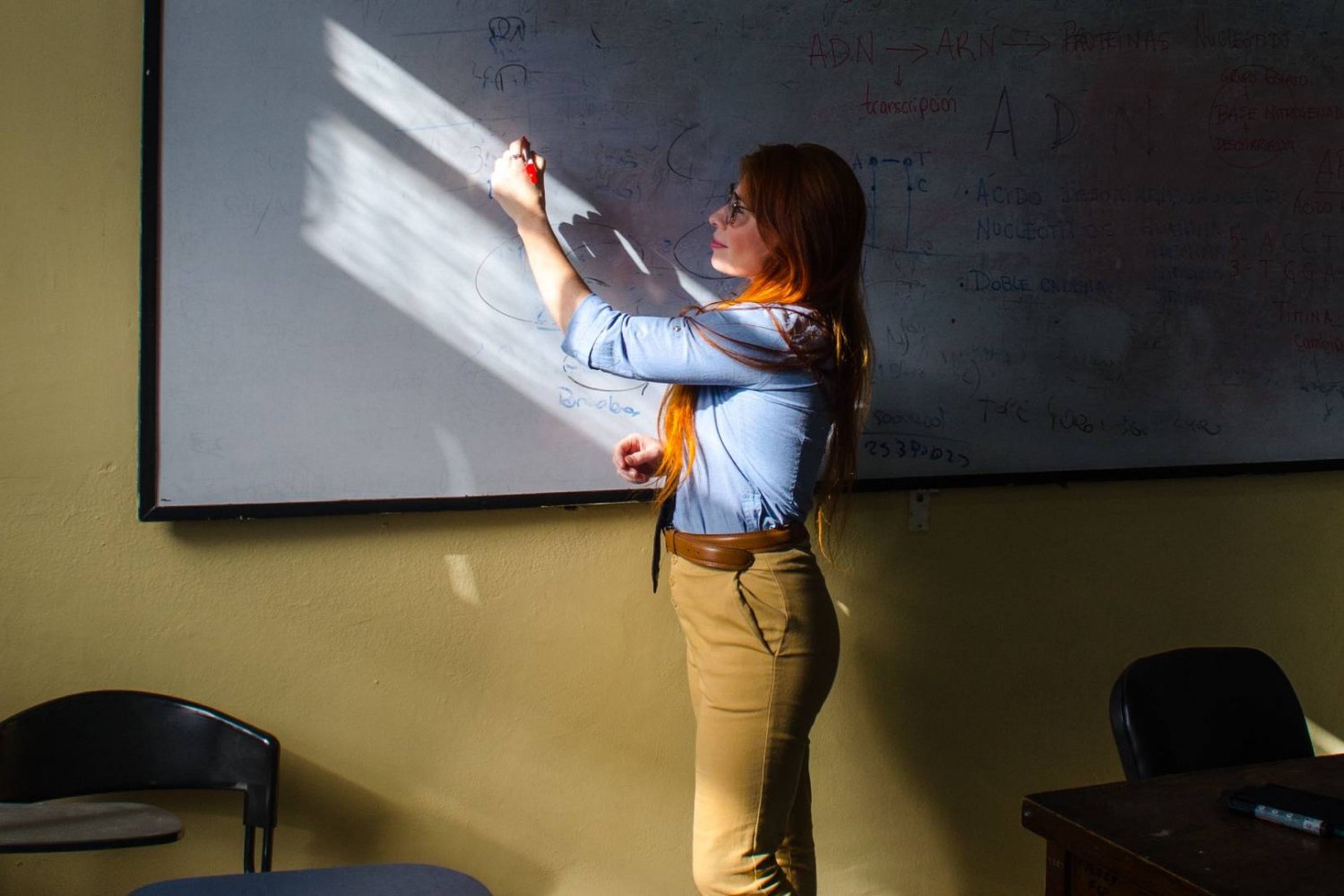 nauczycielka pisze na tablicy w klasie