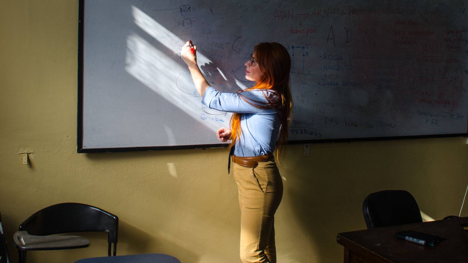 nauczycielka pisze na tablicy w klasie nauczycielka pisze na tablicy w klasie