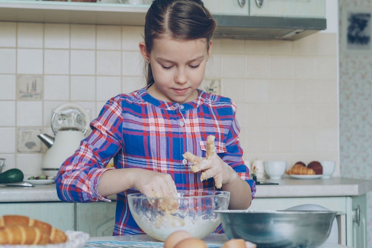 Na zdjęciu dziewczynka piecze ciasto.