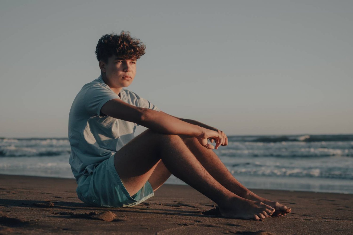 zamyślony nastolatek na plaży