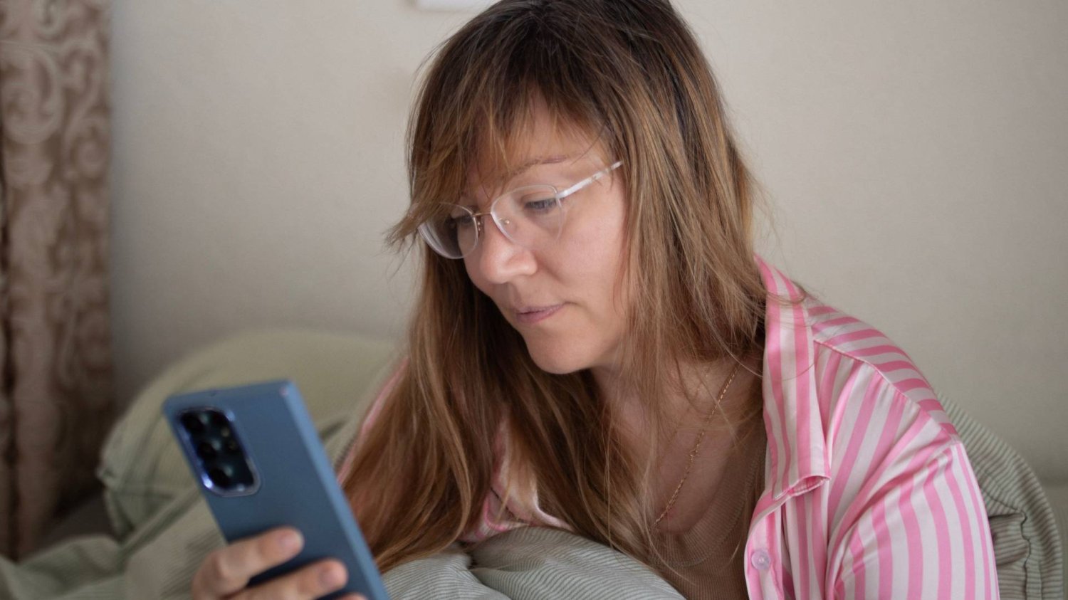 zirytowana mama czyta na smartfonie wiadomości rodziców